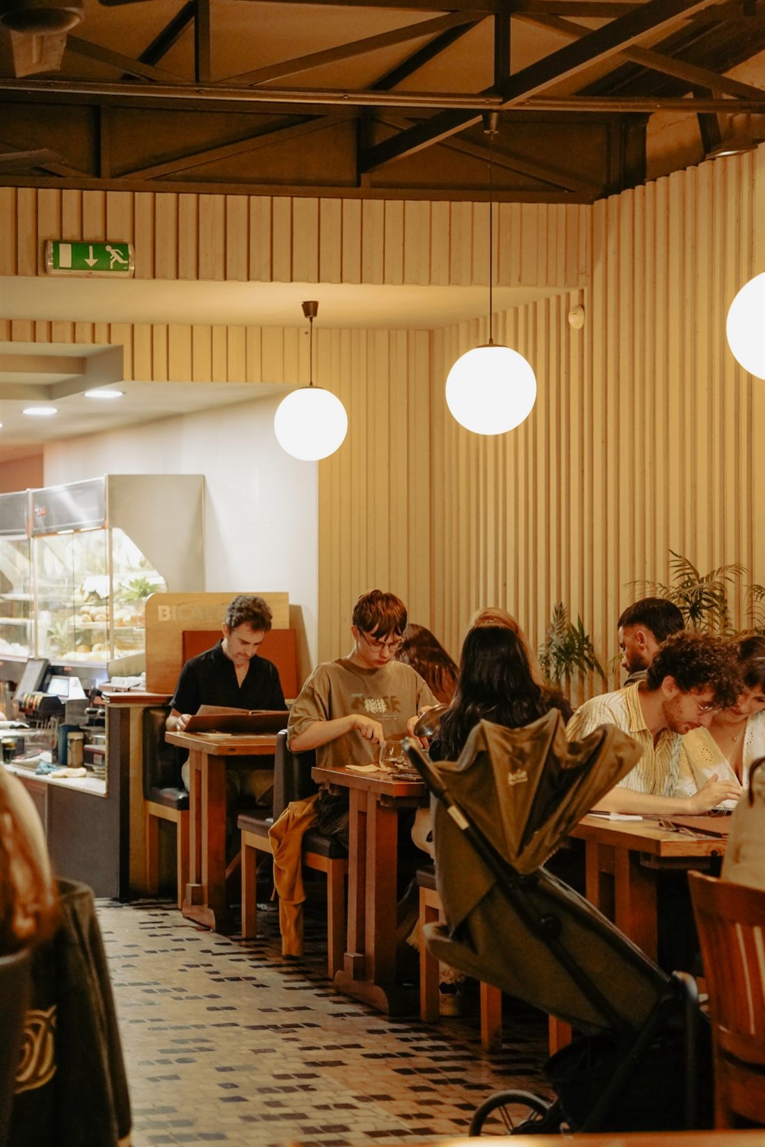 The dining room at Capa na Baixa with slatted walls and globe lights, Porto